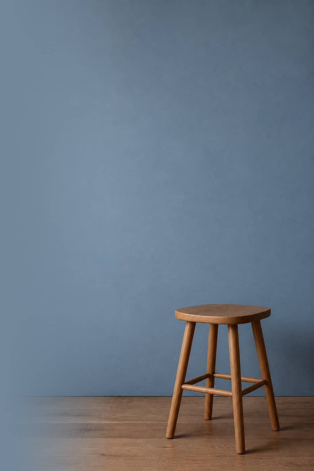 Wooden stool against a dusty blue painted wall